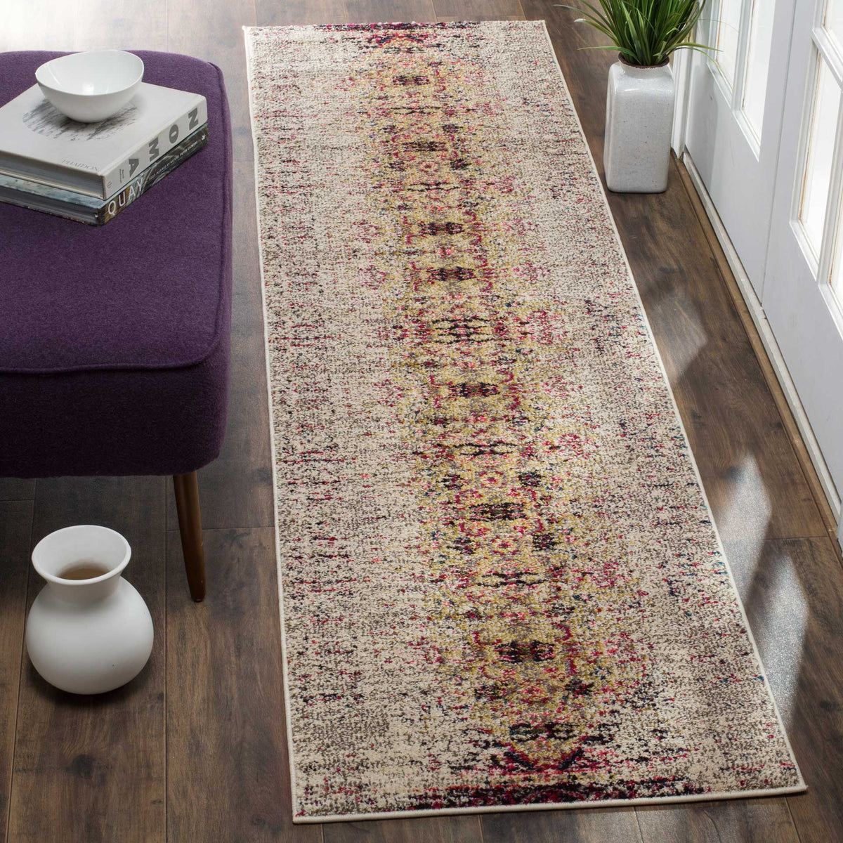 Pink and plum accents bring lively pattern to this ivory runner beside a seating area.