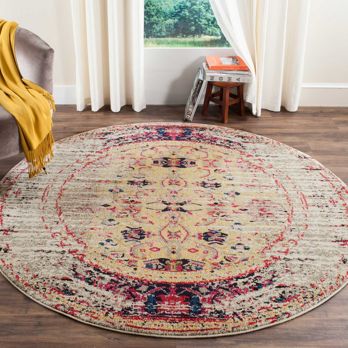 Ivory round rug brightens the floor with pink flourishes and ornate navy detailing.