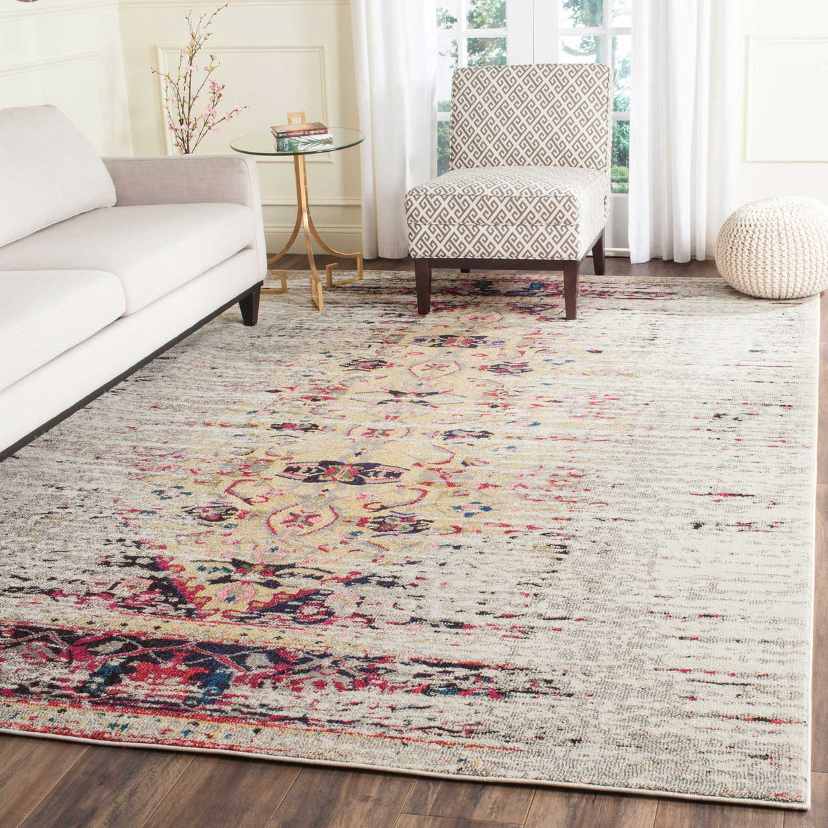 Pink and navy floral motifs add lively color to an ivory rug in a bright sitting area