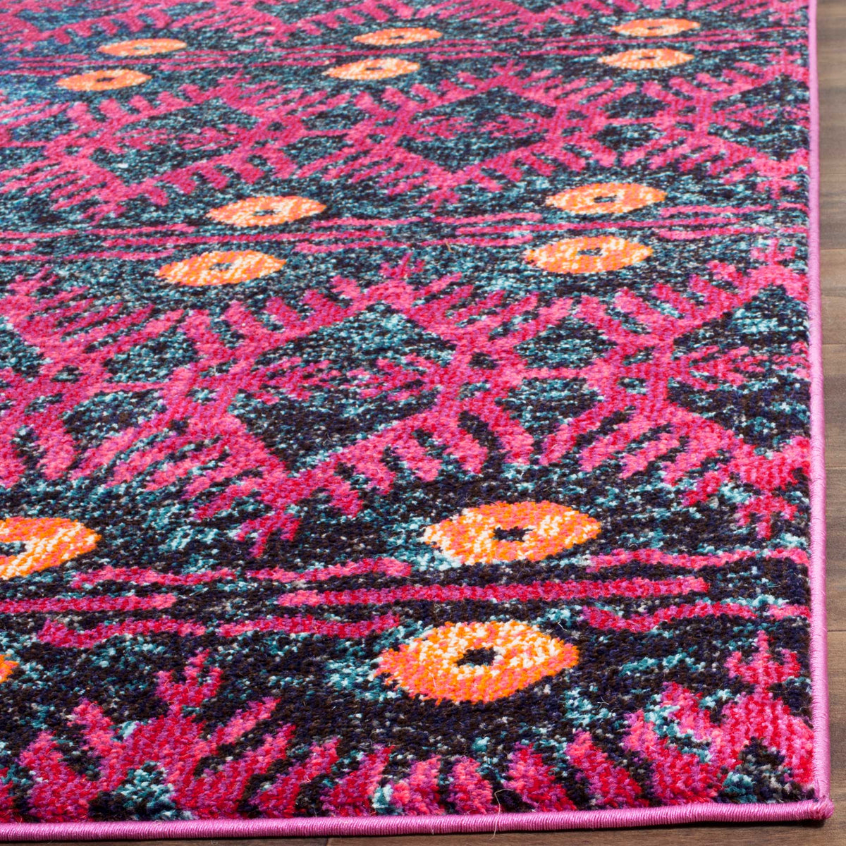 Pink bound edges frame dense fuchsia flourishes, teal flecks and bright orange medallions.