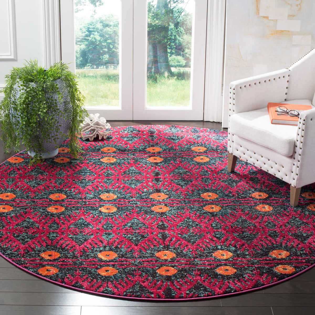Bold round rug with pink diamond patterns and orange accents adds color to a bright sitting area