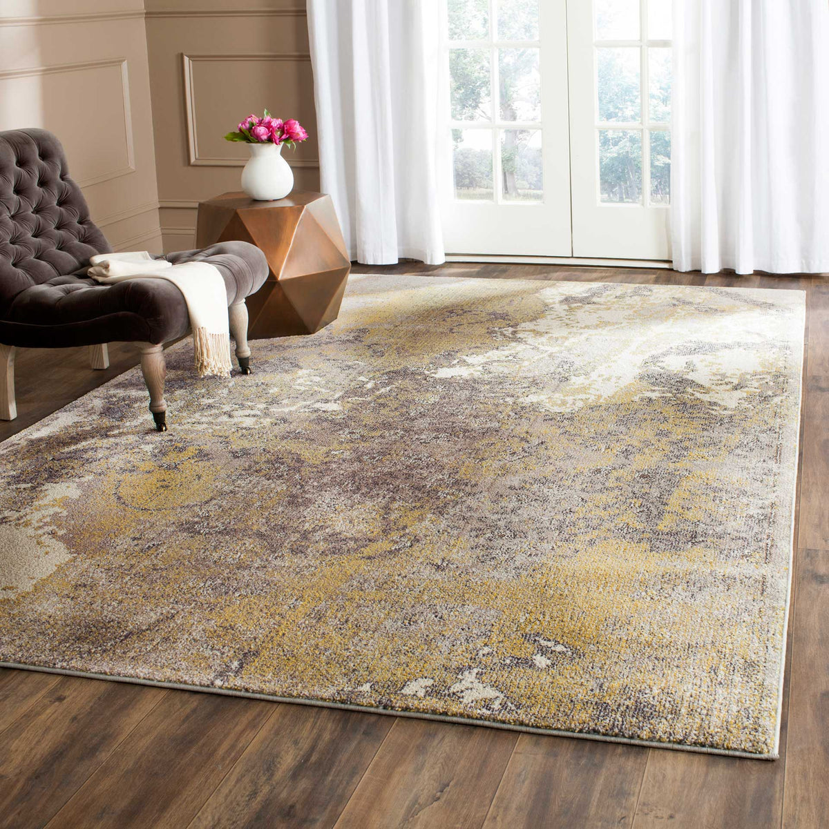 A softly distressed gold and gray rug lends warmth and artistry to a cozy sitting area.