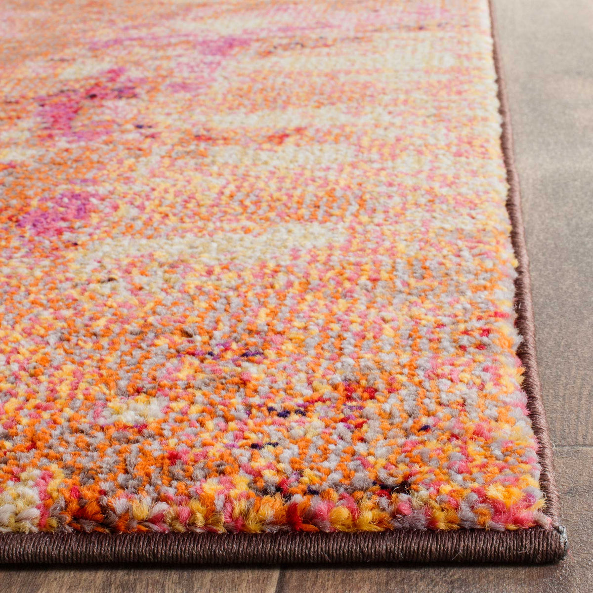 Dense, multicolored pile meets neatly bound edges in soft orange, pink and cream.