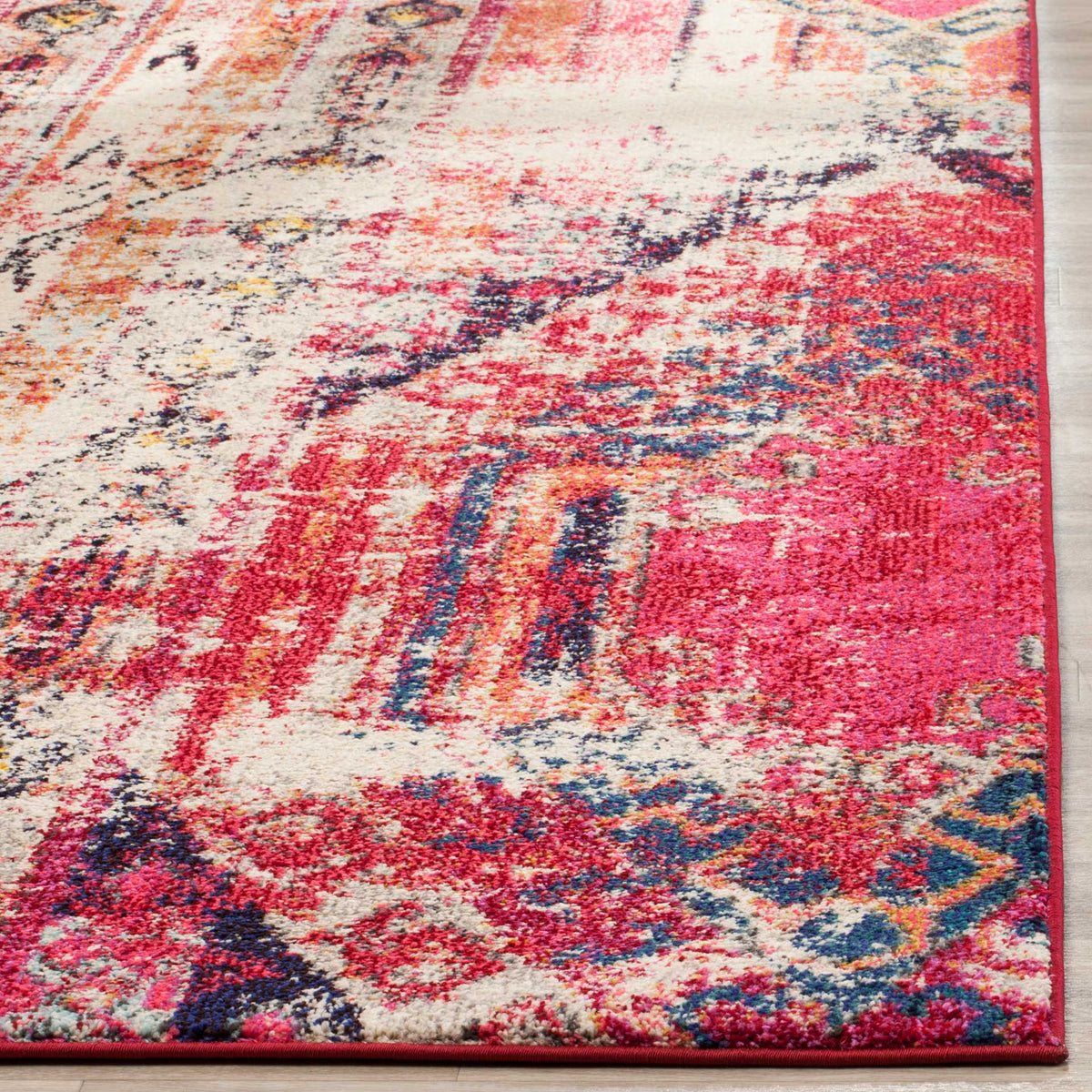 Colorful pile and a pink bound edge highlight the rug's weathered geometric pattern