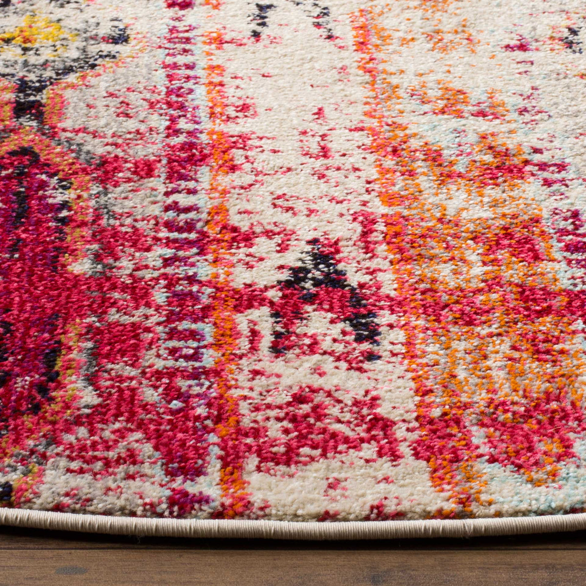 Magenta and orange accents reveal a textured pile and neatly bound rug edge