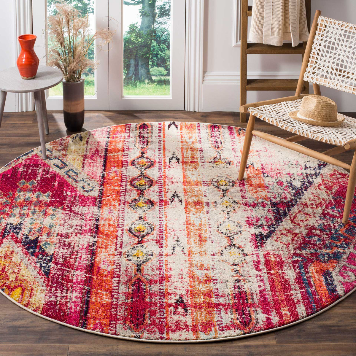 A round rug brings bold magenta bands and vintage-style motifs to a seating area