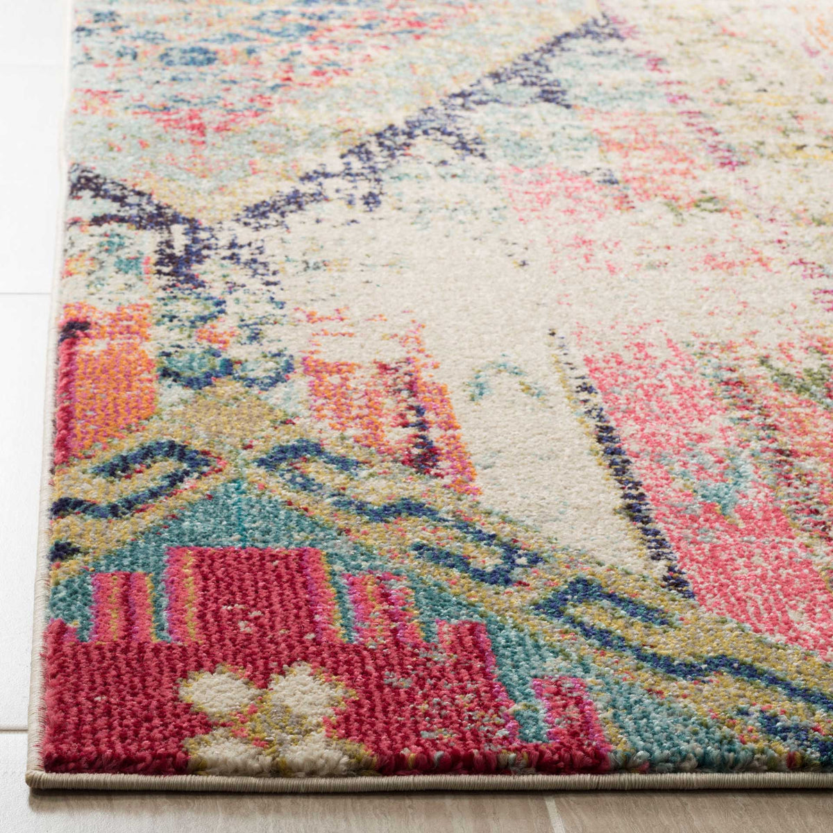 Soft pile and a neatly bound edge reveal vivid coral, teal, and cream geometric detail