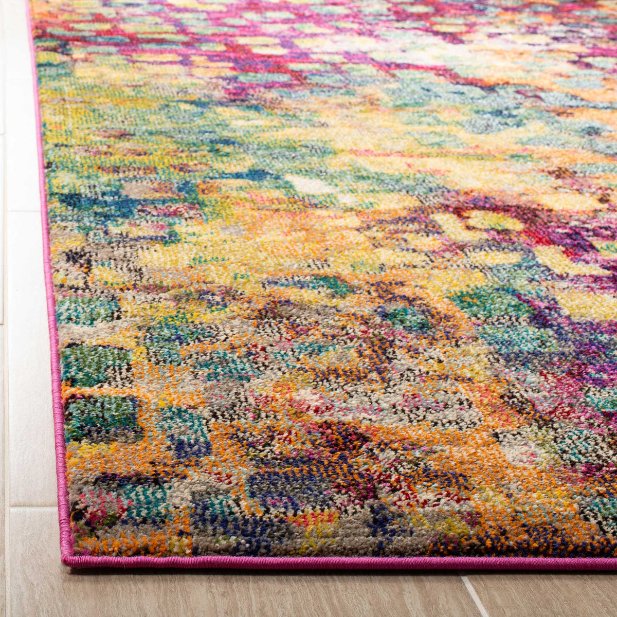 Bright pink binding frames a plush blend of orange, teal, and yellow yarns