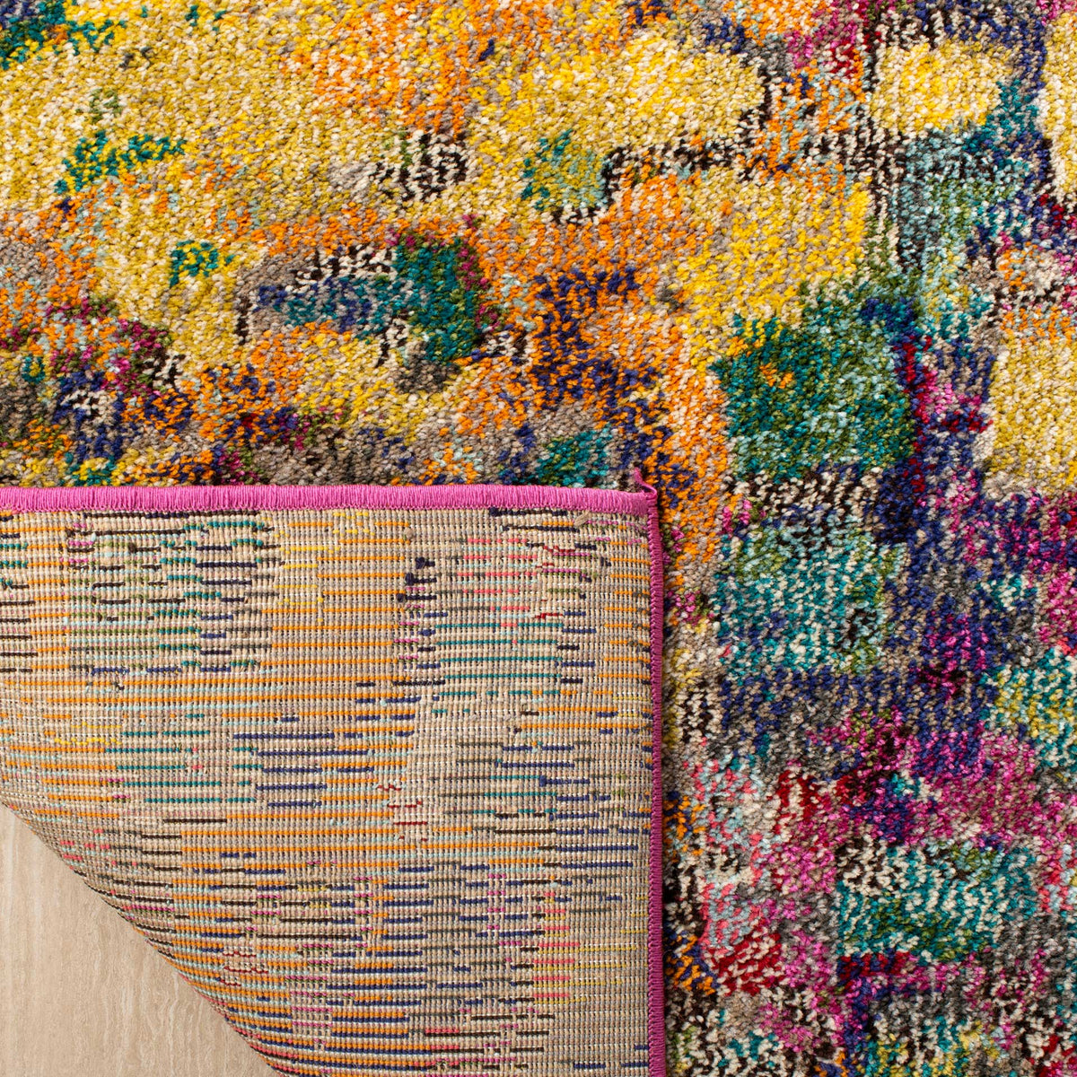Woven backing reveals multicolor threads beneath a bright pink bound edge
