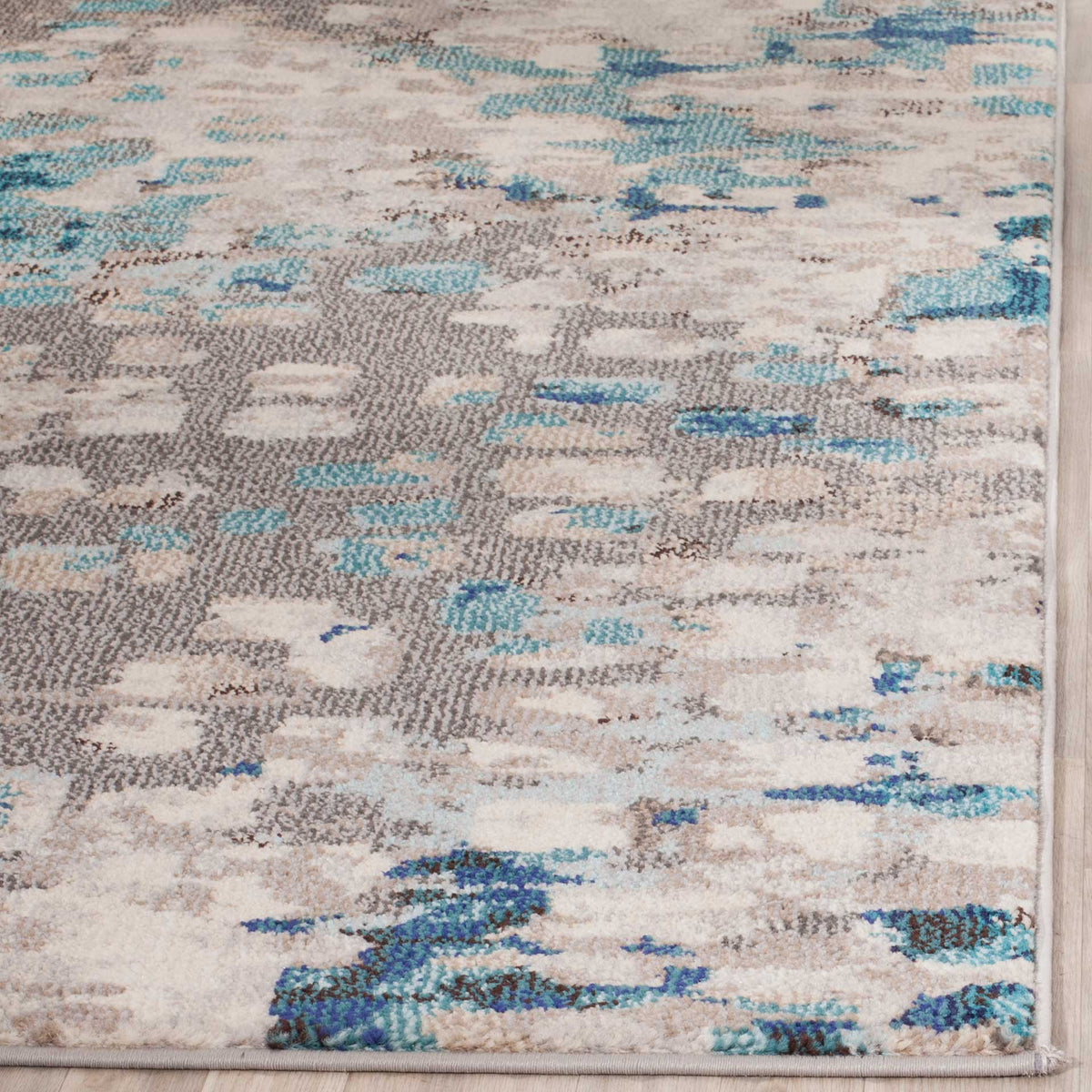 Soft gray and teal pile meets a neat bound edge amid scattered blue markings
