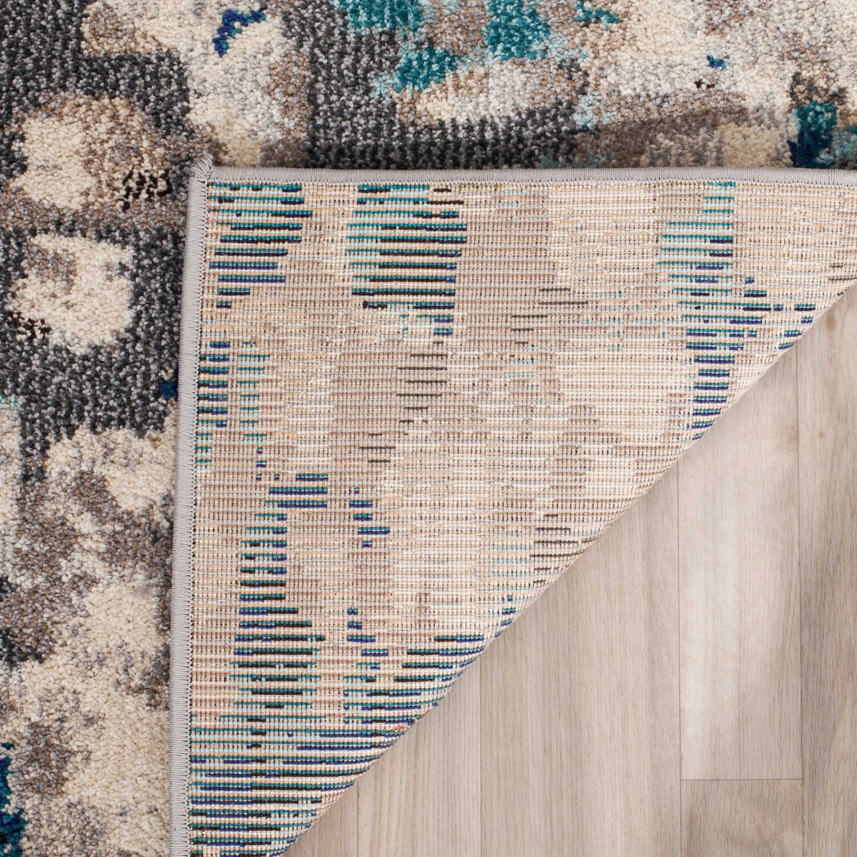 Woven cotton backing and bound edges complement the textured gray and teal pile