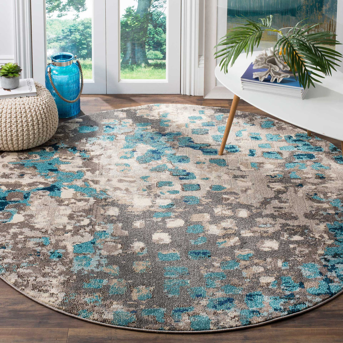 Blue highlights scatter across a round gray rug, adding color beneath contemporary furnishings