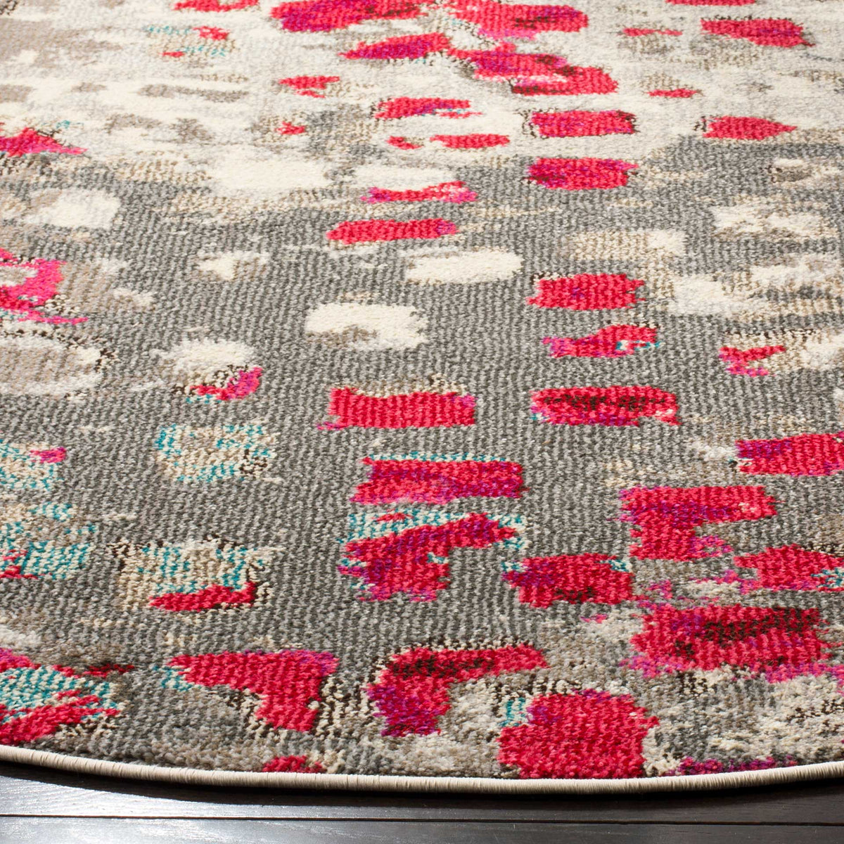 Bright fuchsia and gray yarns form a textured pattern above a neatly bound edge