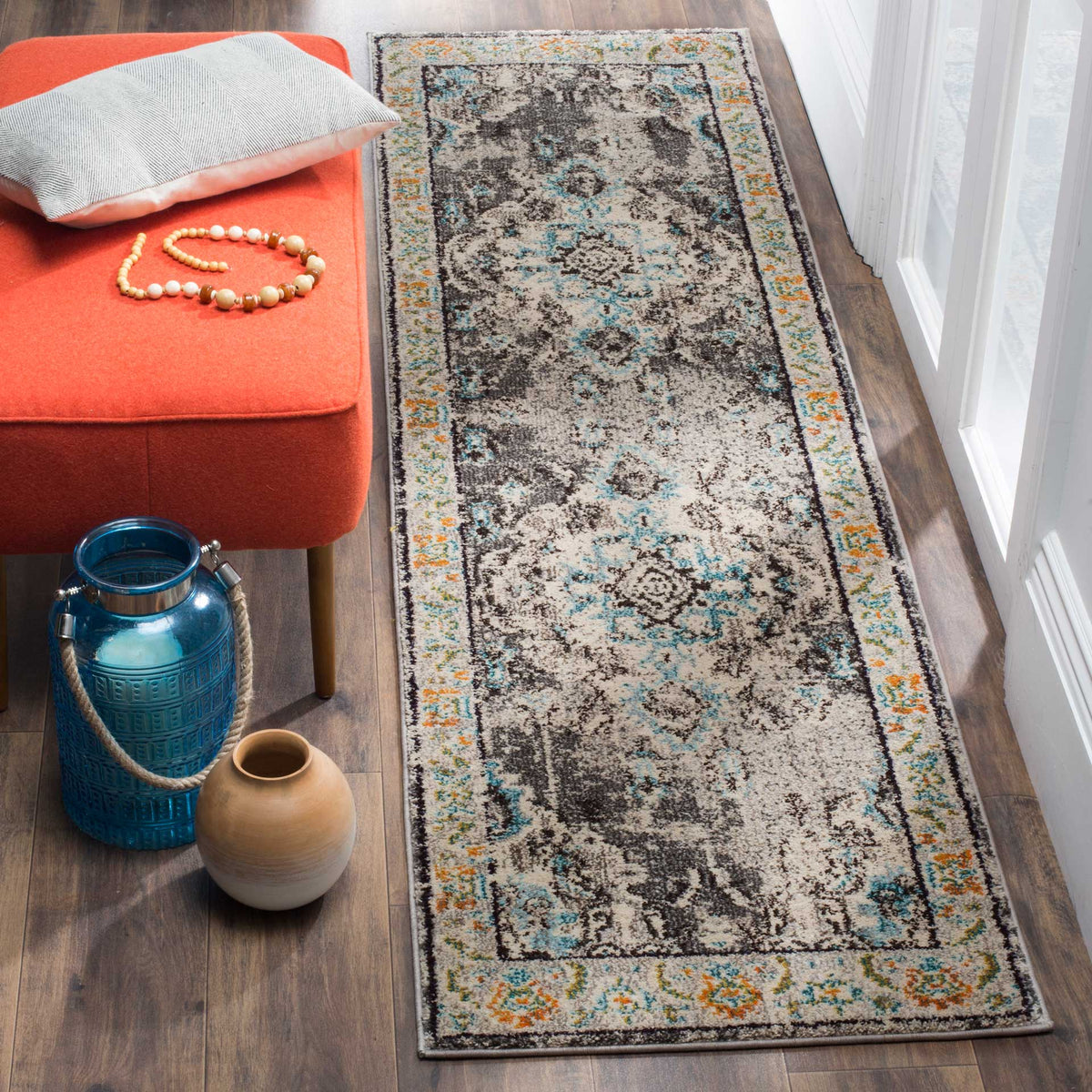 Soft gray runner with blue floral accents and an ornate border complements a wood-floored walkway