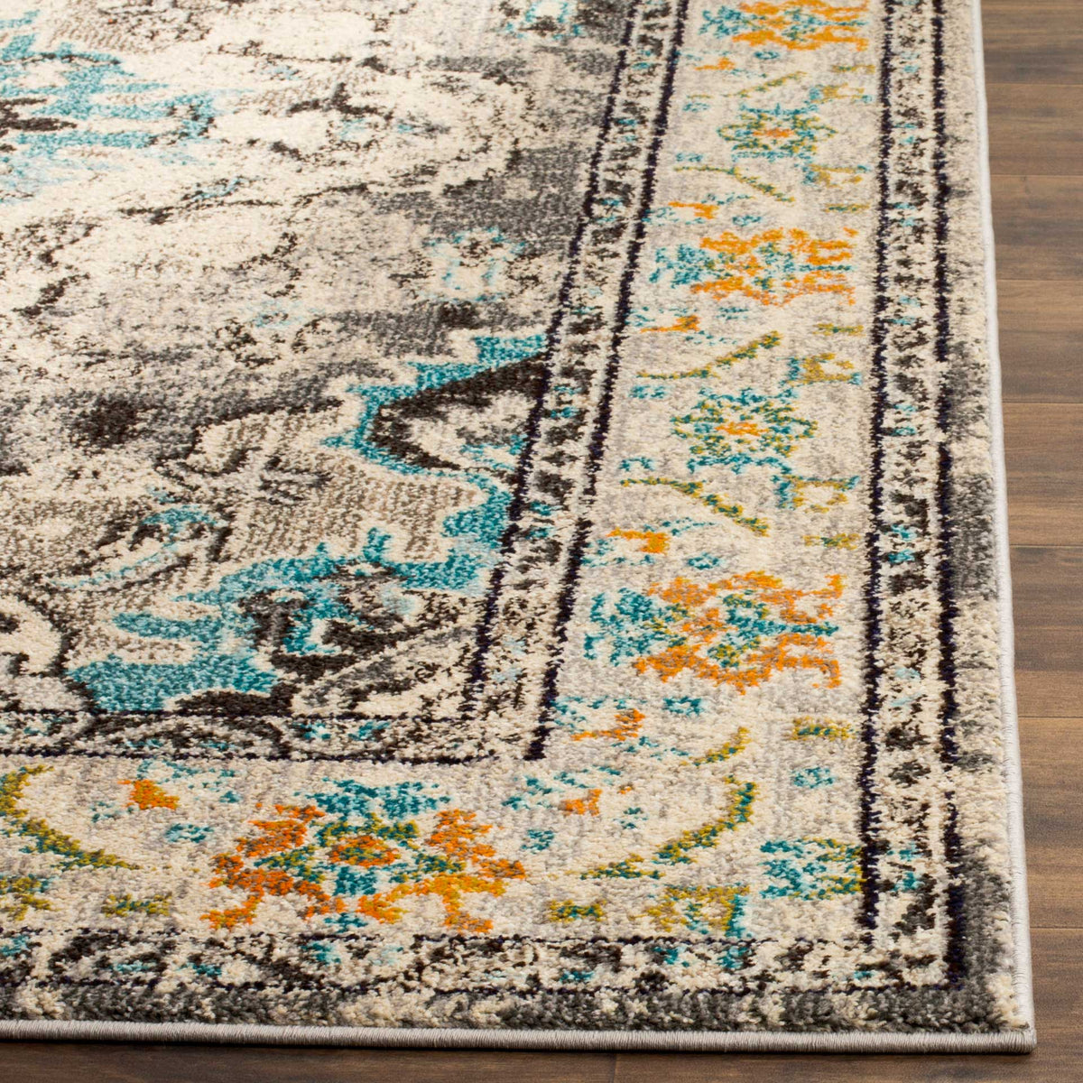 Distressed gray pile meets a cream floral border with orange details and a neatly finished edge