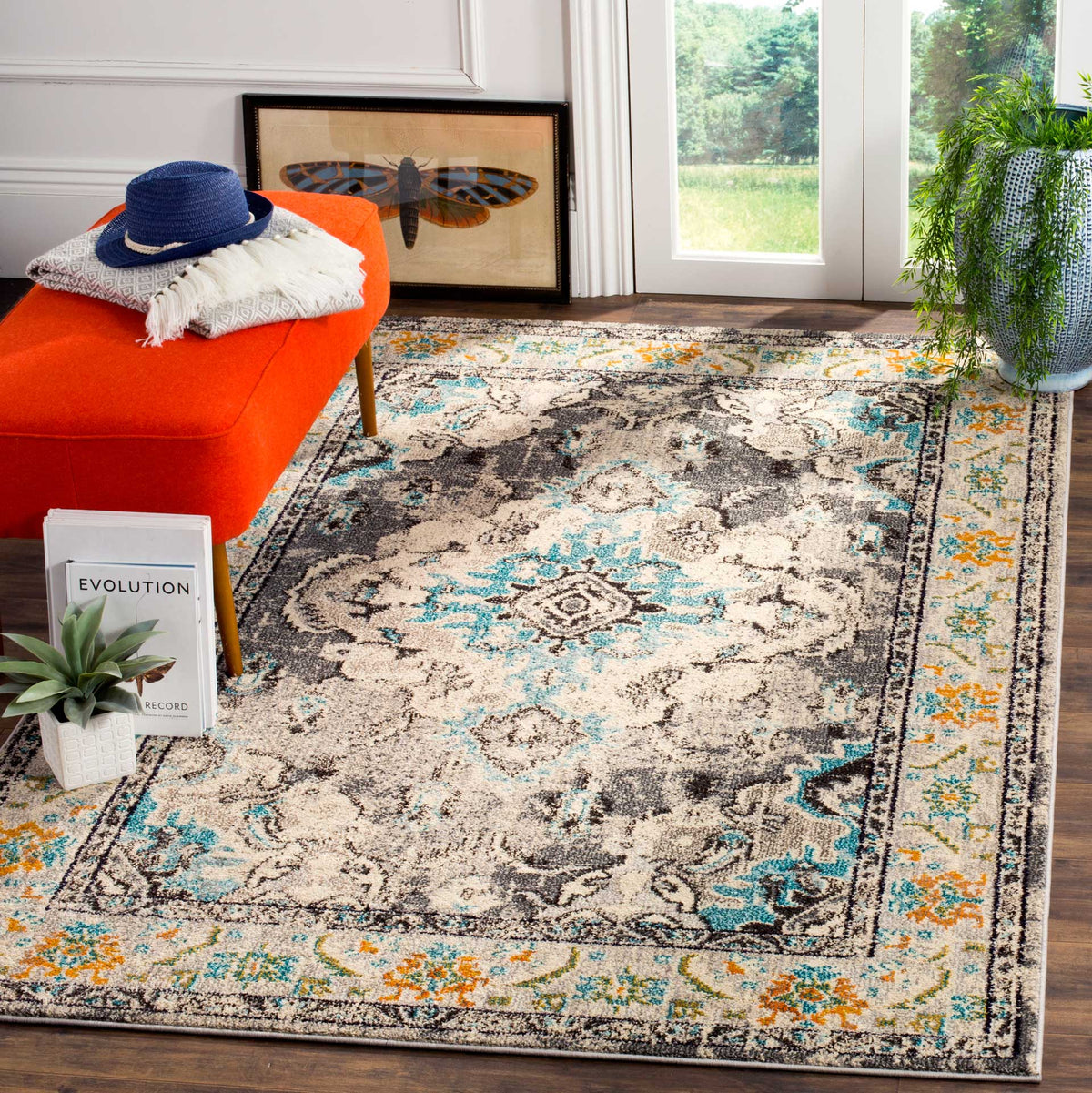 Gray medallion rug brightens a seating area with light blue flourishes and orange border accents