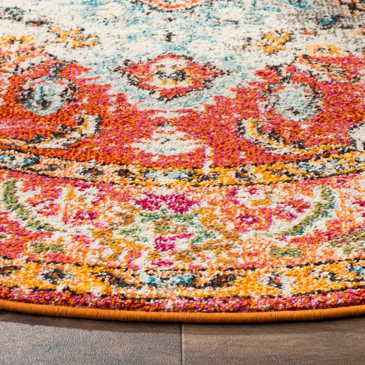 Orange and fuchsia florals surround light blue detailing in a textured rug with a bound edge