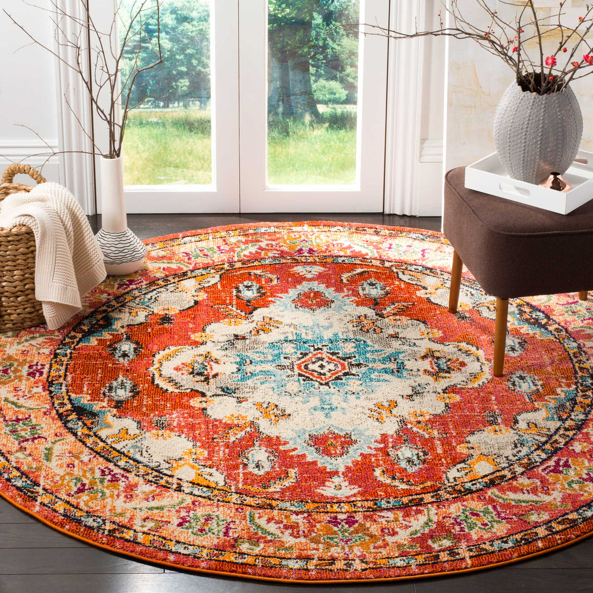 A bright orange field surrounds the light blue and cream medallion of this floral round rug