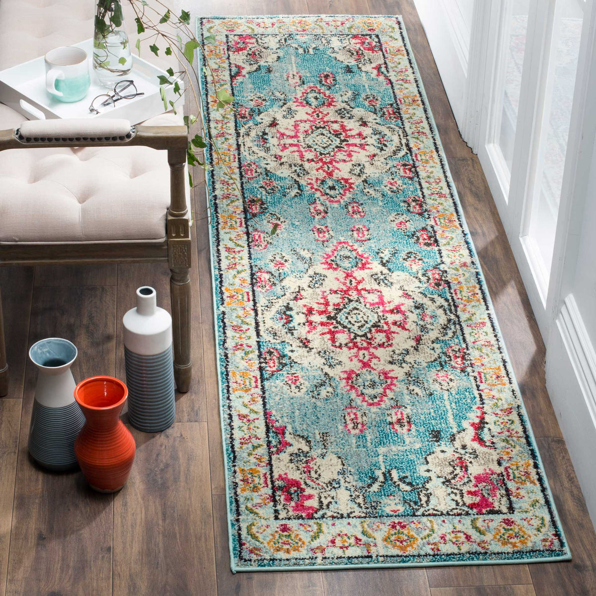 Light blue and fuchsia runner adds vivid floral pattern beside a tufted chair