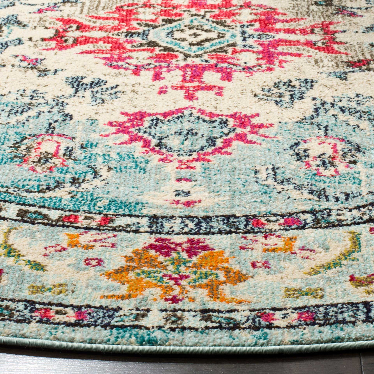 Bright fuchsia medallion details and orange blossoms pop against the light blue and cream textured pile