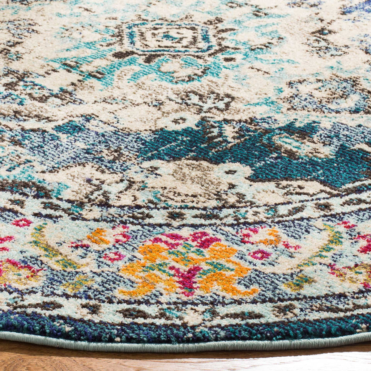 Cream medallion and navy motifs transition to a floral border brightened by orange and pink