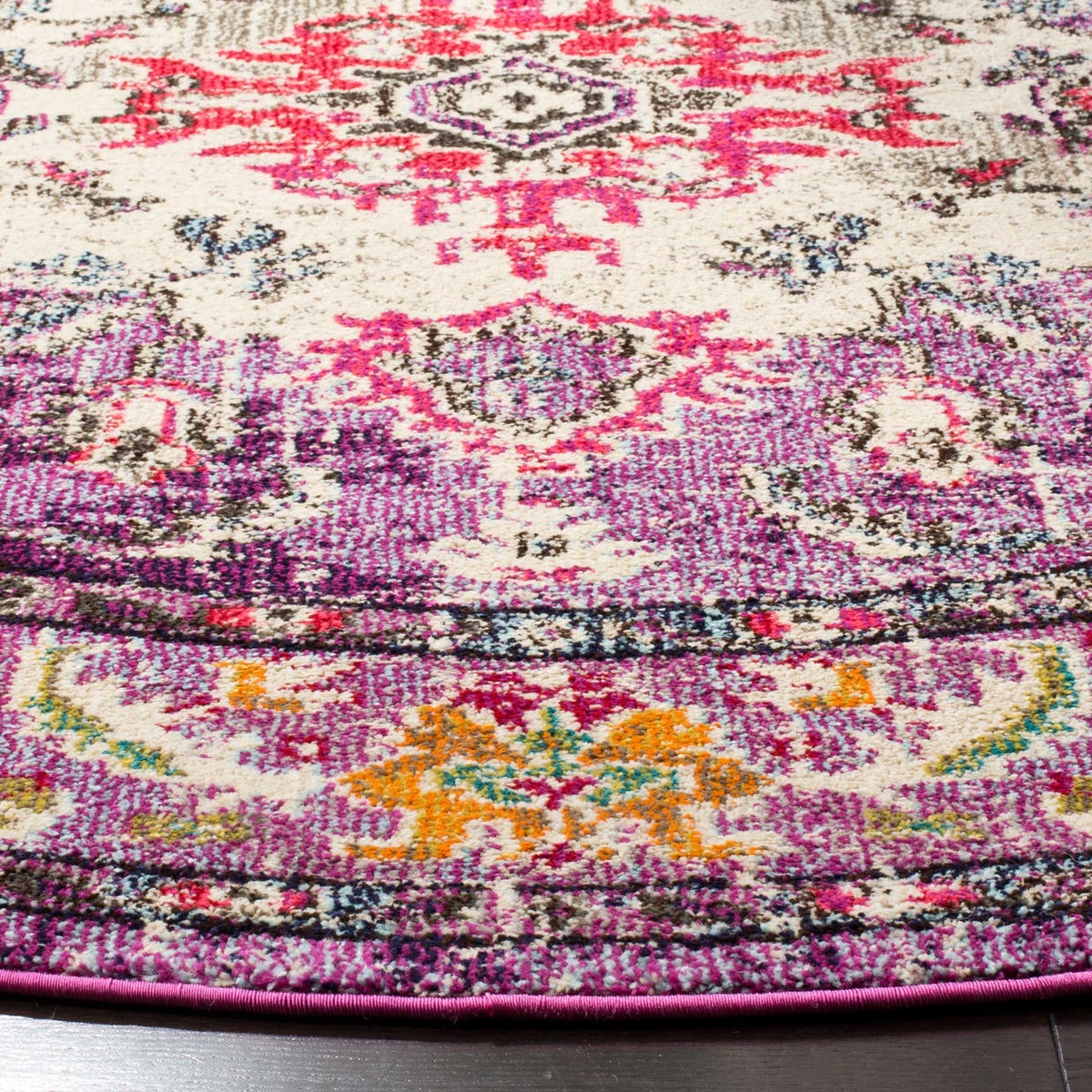 Violet and fuchsia pile surrounds cream medallion details and an orange floral border near the finished edge