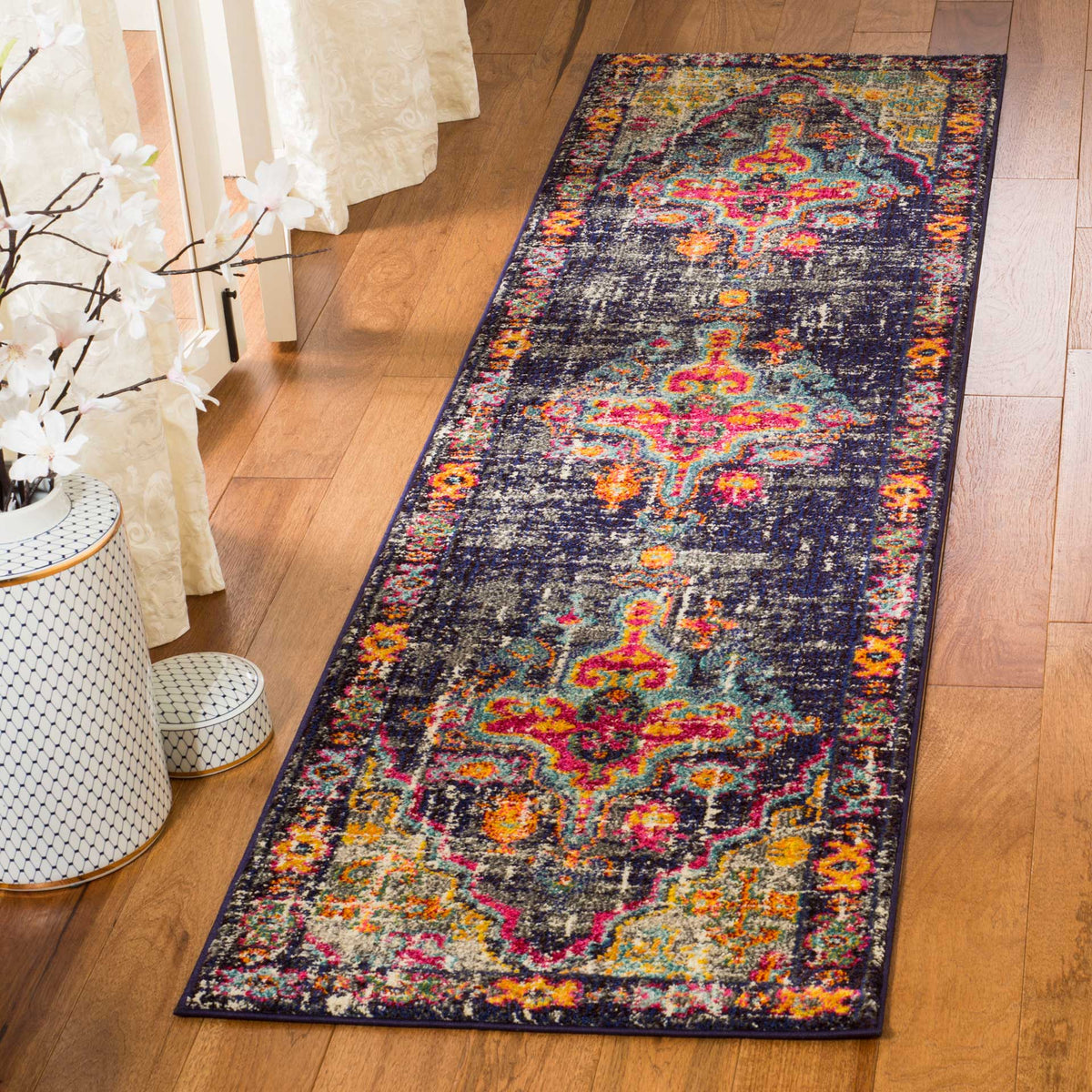 Bright orange, teal and fuchsia motifs enliven this long, distressed gray runner