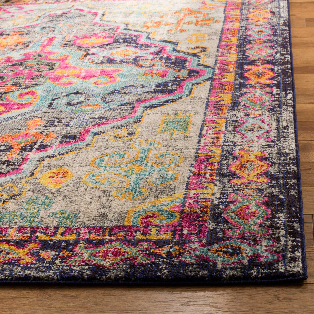 An ornate dark border frames textured gray pile with fuchsia, turquoise, and golden flourishes.