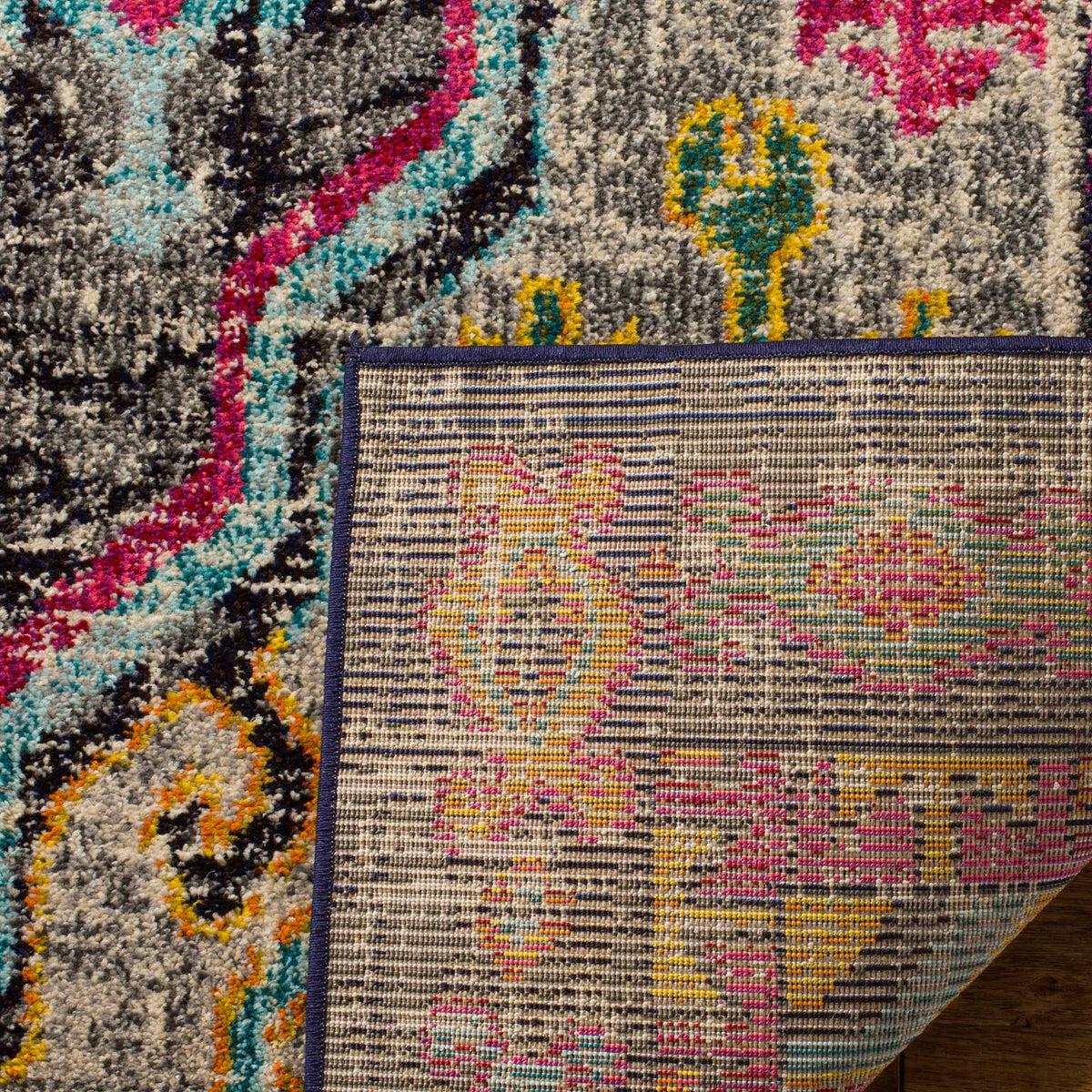 A turned-up corner reveals woven cotton backing beneath the rug's colorful, textured pile.