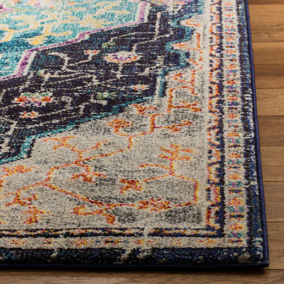 Rug corner with orange floral detailing, multicolored borders, and a dark finished edge