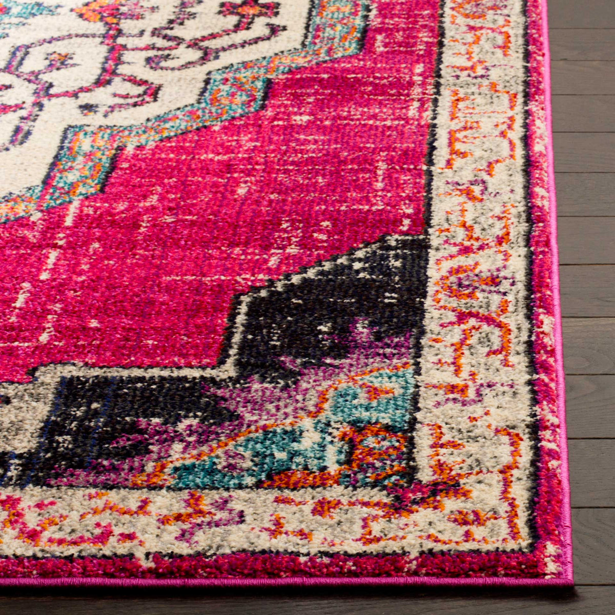 A fuchsia field and dark corner detail meet the cream floral border at a neatly bound edge.