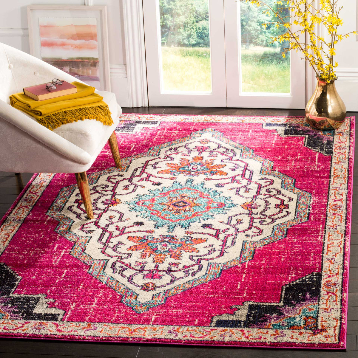 A vivid pink field and ivory medallion bring bold color to the floor beside a cream chair.