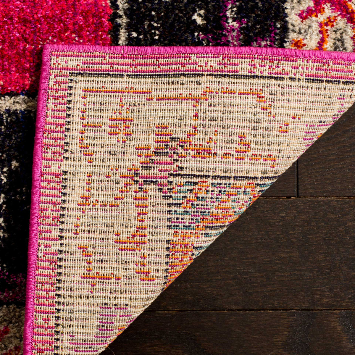Woven cotton backing and a pink bound edge complement the bright fuchsia and ivory pile.