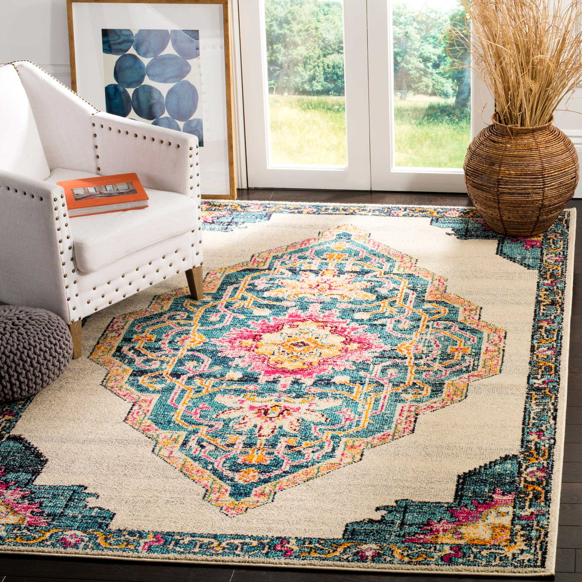 An ornate teal and pink medallion adds cheerful color to the cream rug beneath a white armchair.
