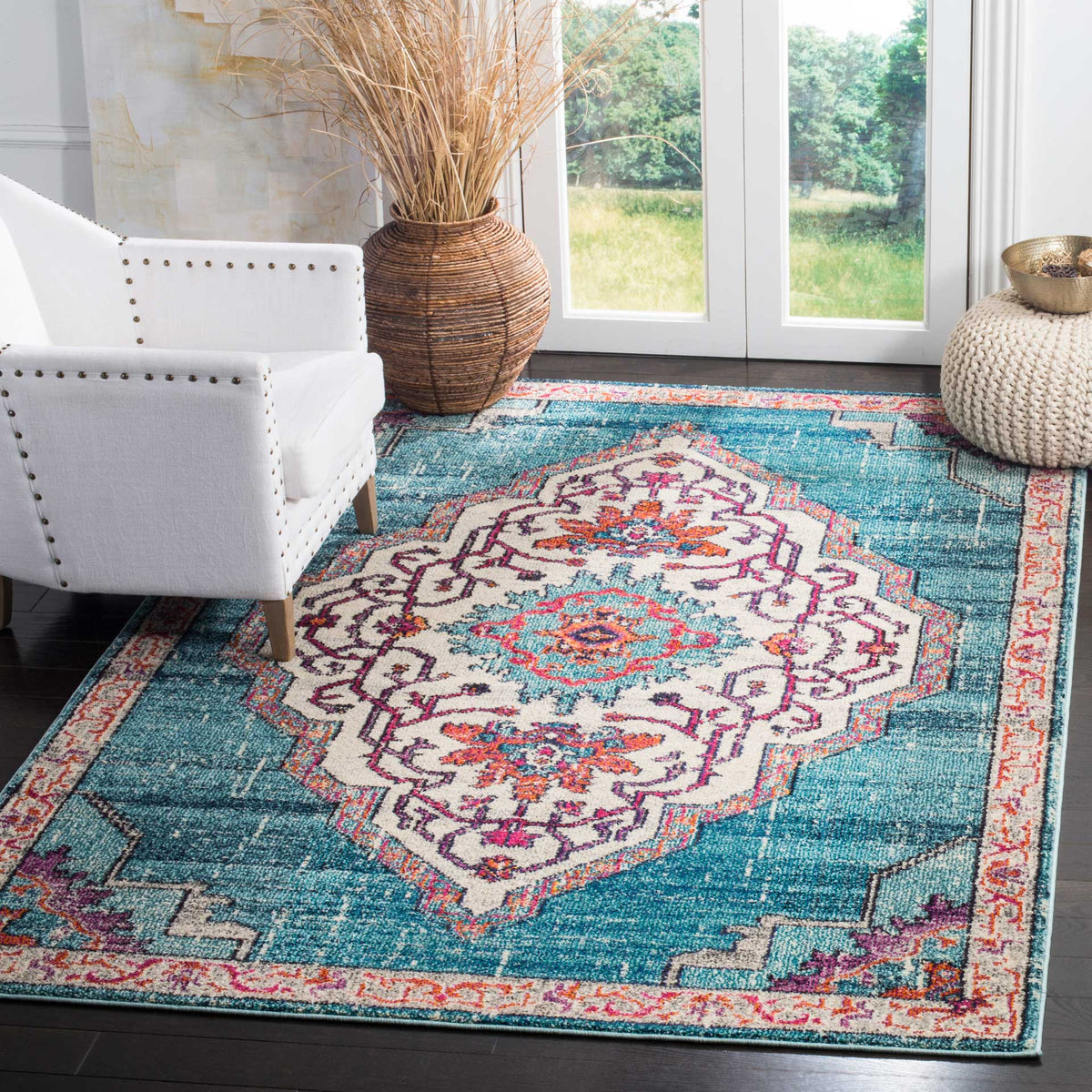 A teal and ivory medallion rug brings lively color beside a white armchair and woven accents.