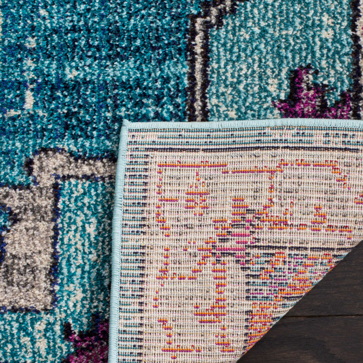 Woven cotton backing and a blue bound edge support the rug's richly colored patterned pile.