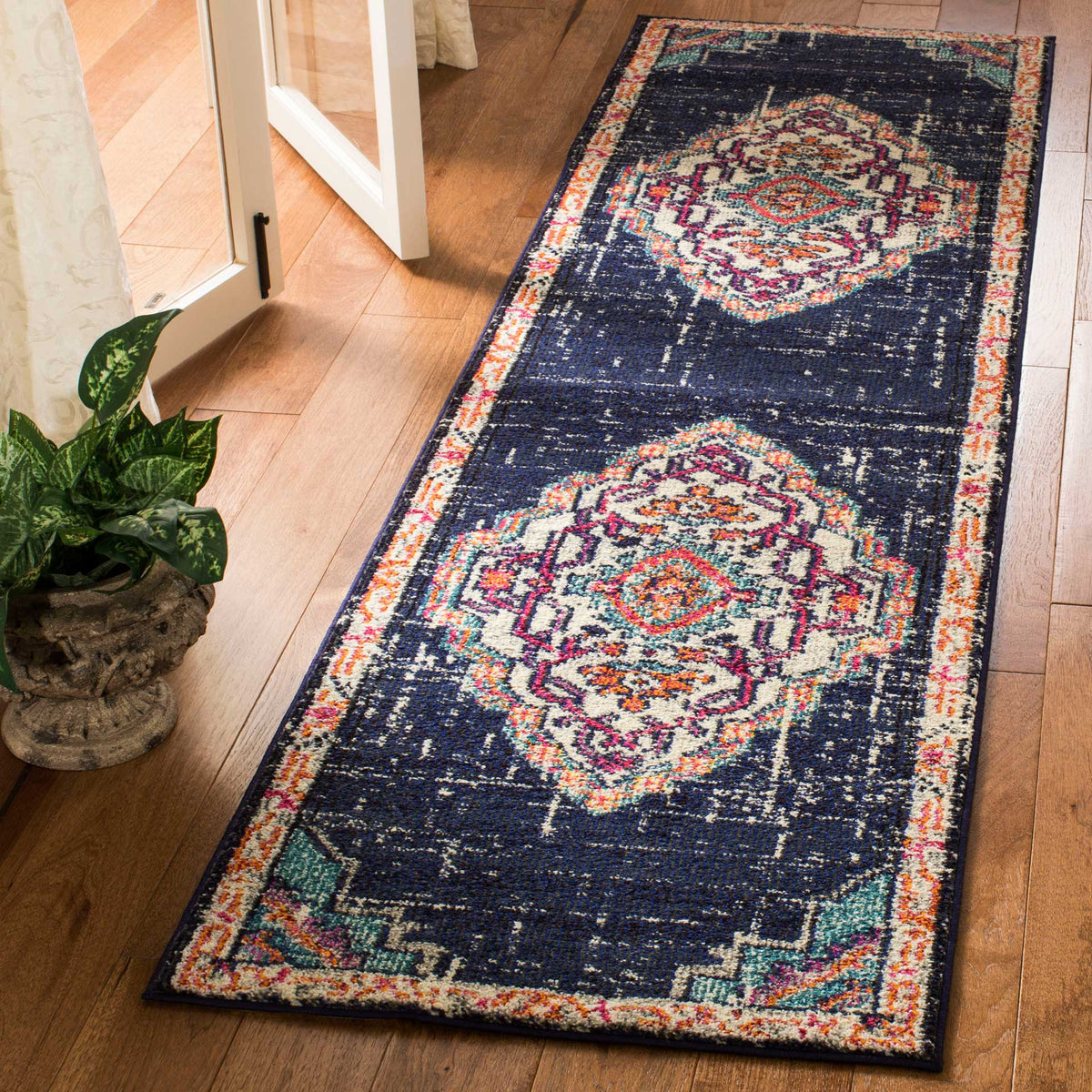 Bright red and teal accents bring a lively look to this dark, vintage-inspired runner rug