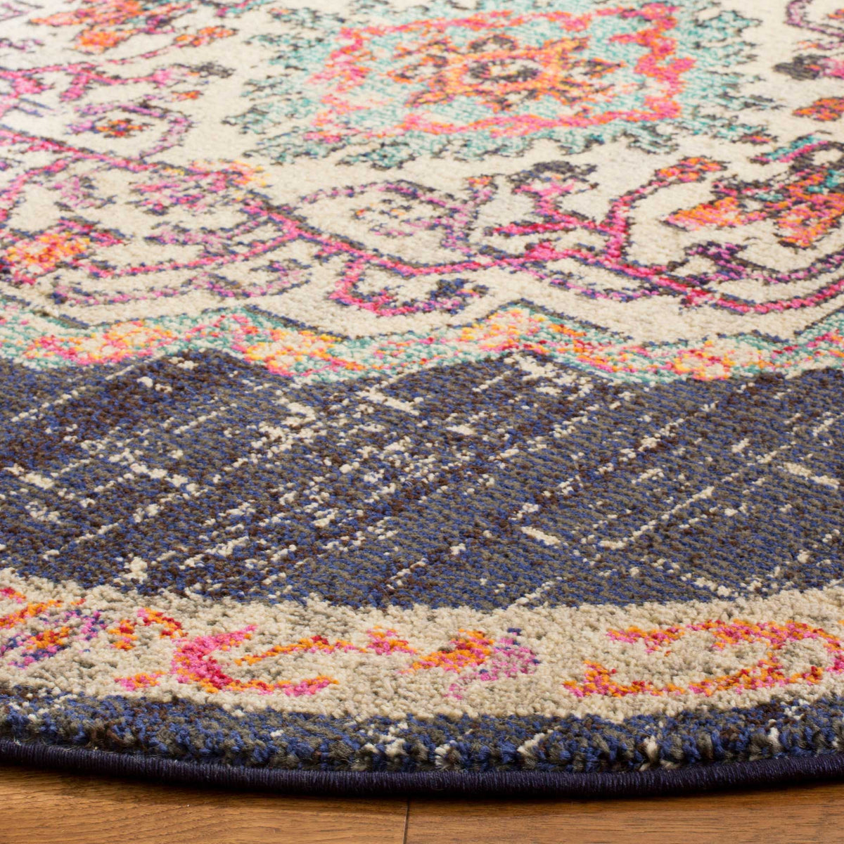 Textured blue-black pile, a cream floral border, and dark bound edging give this round rug depth.