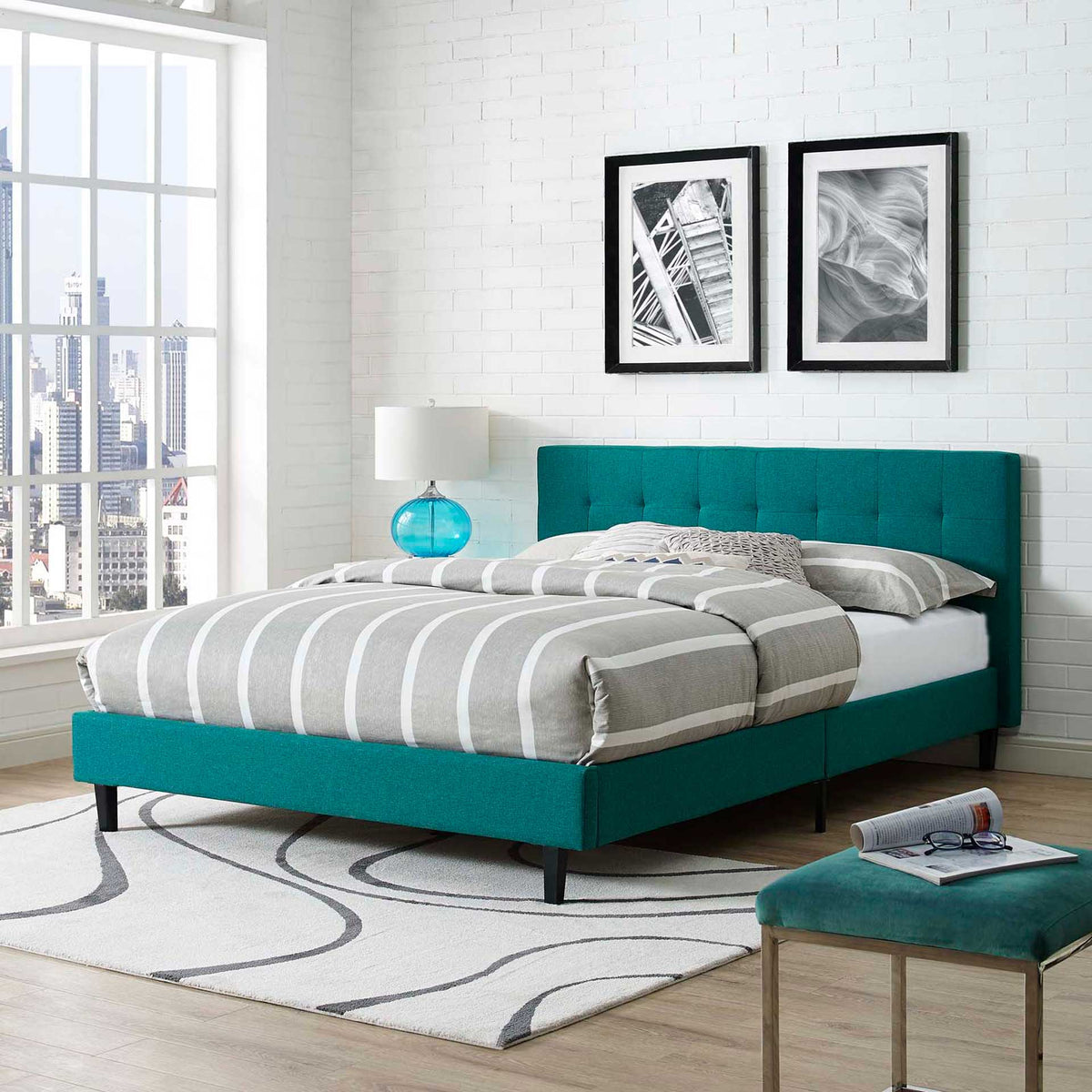 A vibrant teal headboard and upholstered platform base bring color to a bright bedroom.