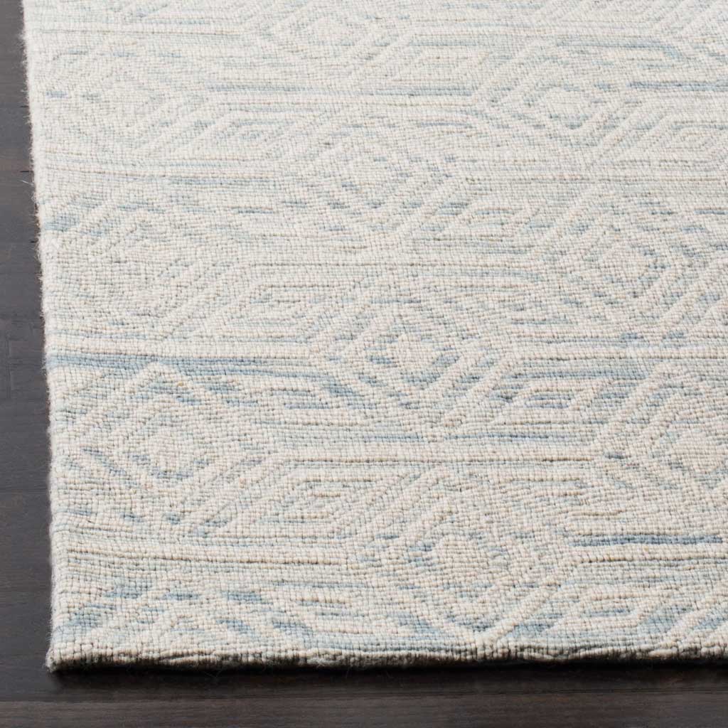 Subtle blue diamonds and woven lines meet a neatly finished edge on this ivory wool rug