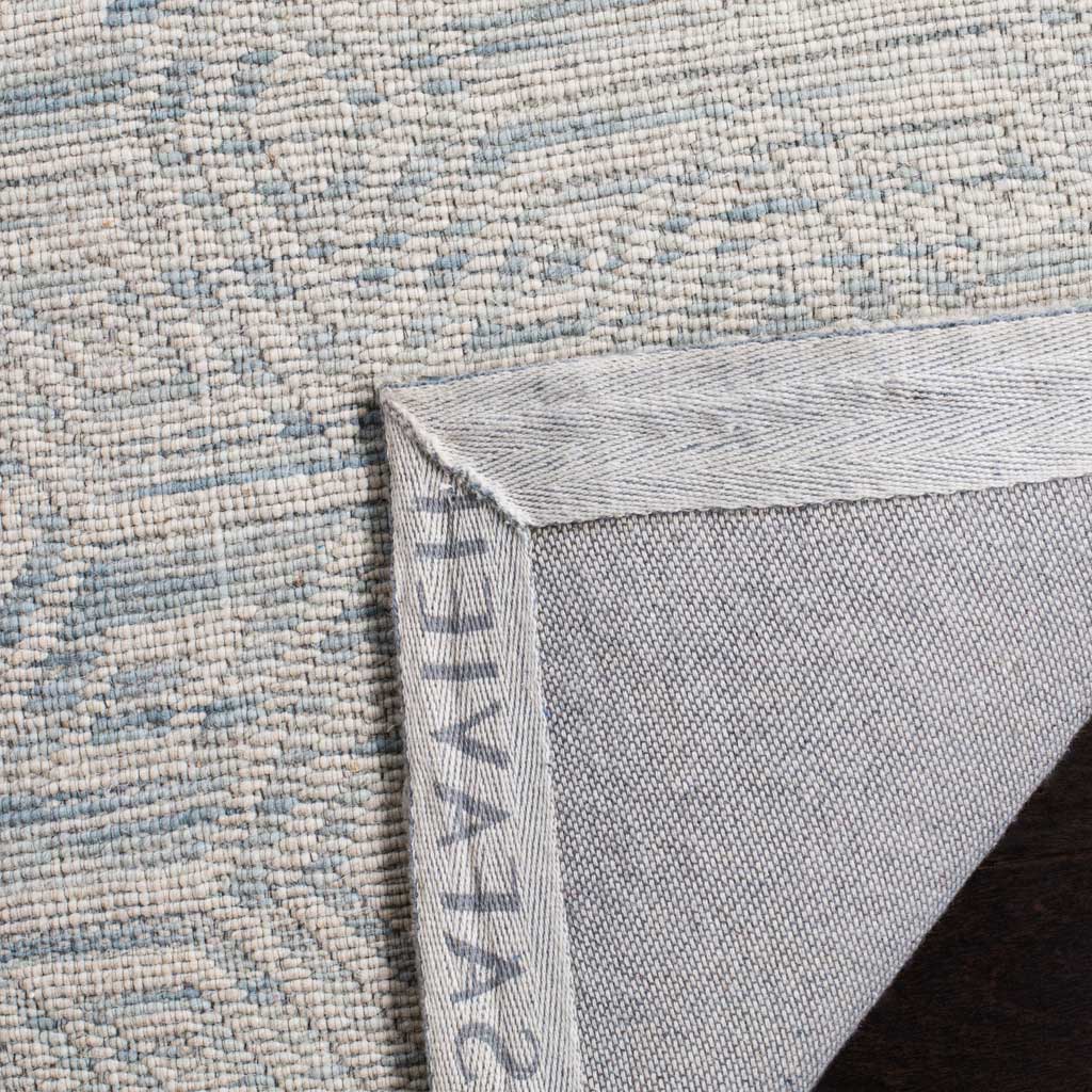 A sturdy cotton backing supports the textured blue and ivory wool rug