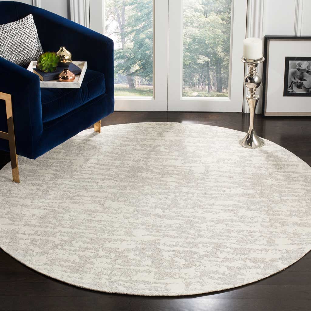 Round light gray and ivory rug lends a soft, distressed pattern to the living area