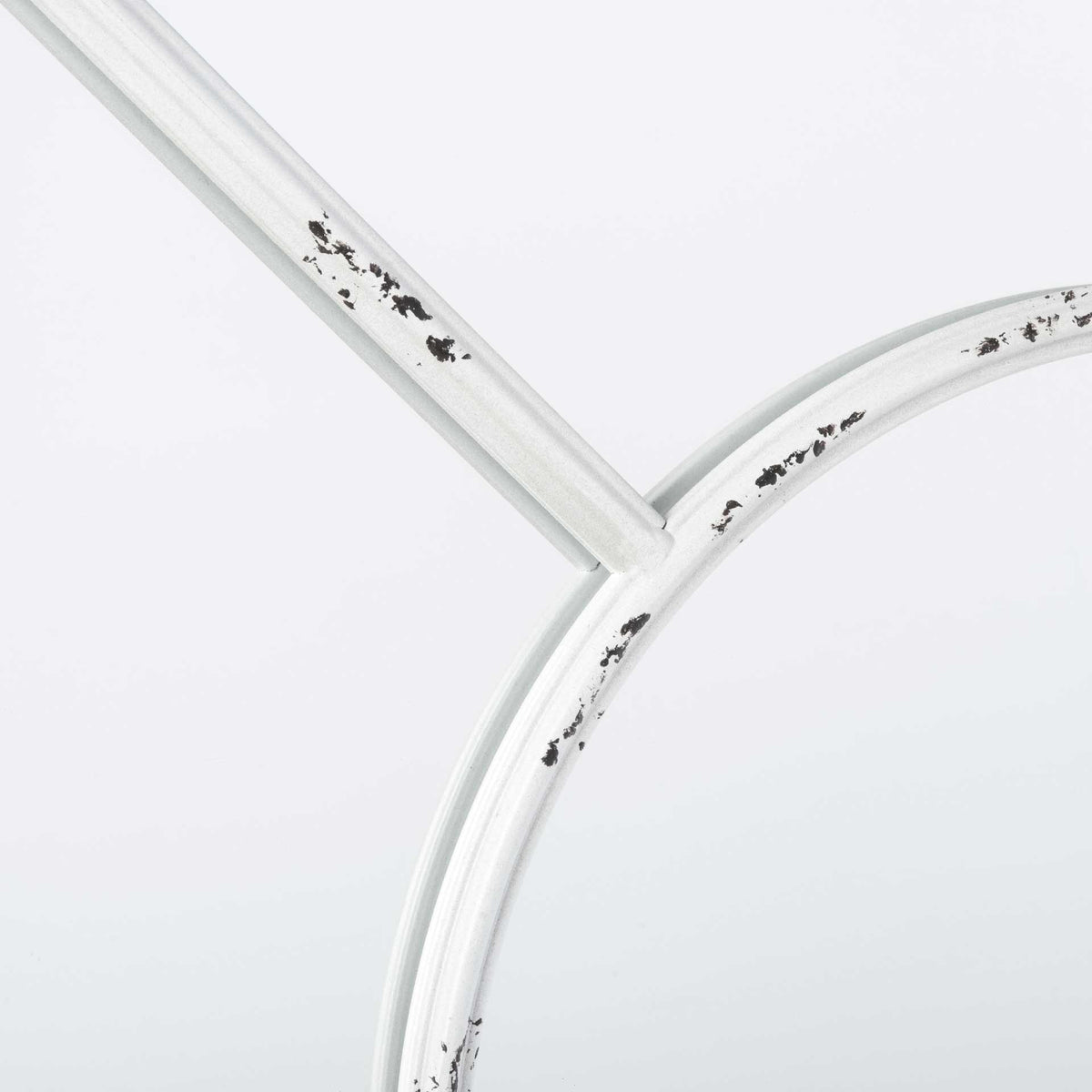 Dark flecks break up the distressed white finish on the mirror's slim metal frame