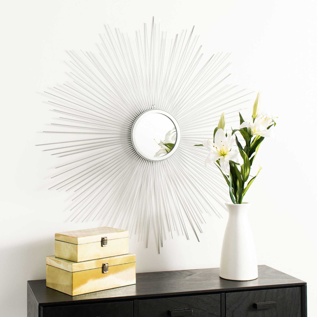 Silver sunburst rays bring airy shimmer to the wall above a dark console.