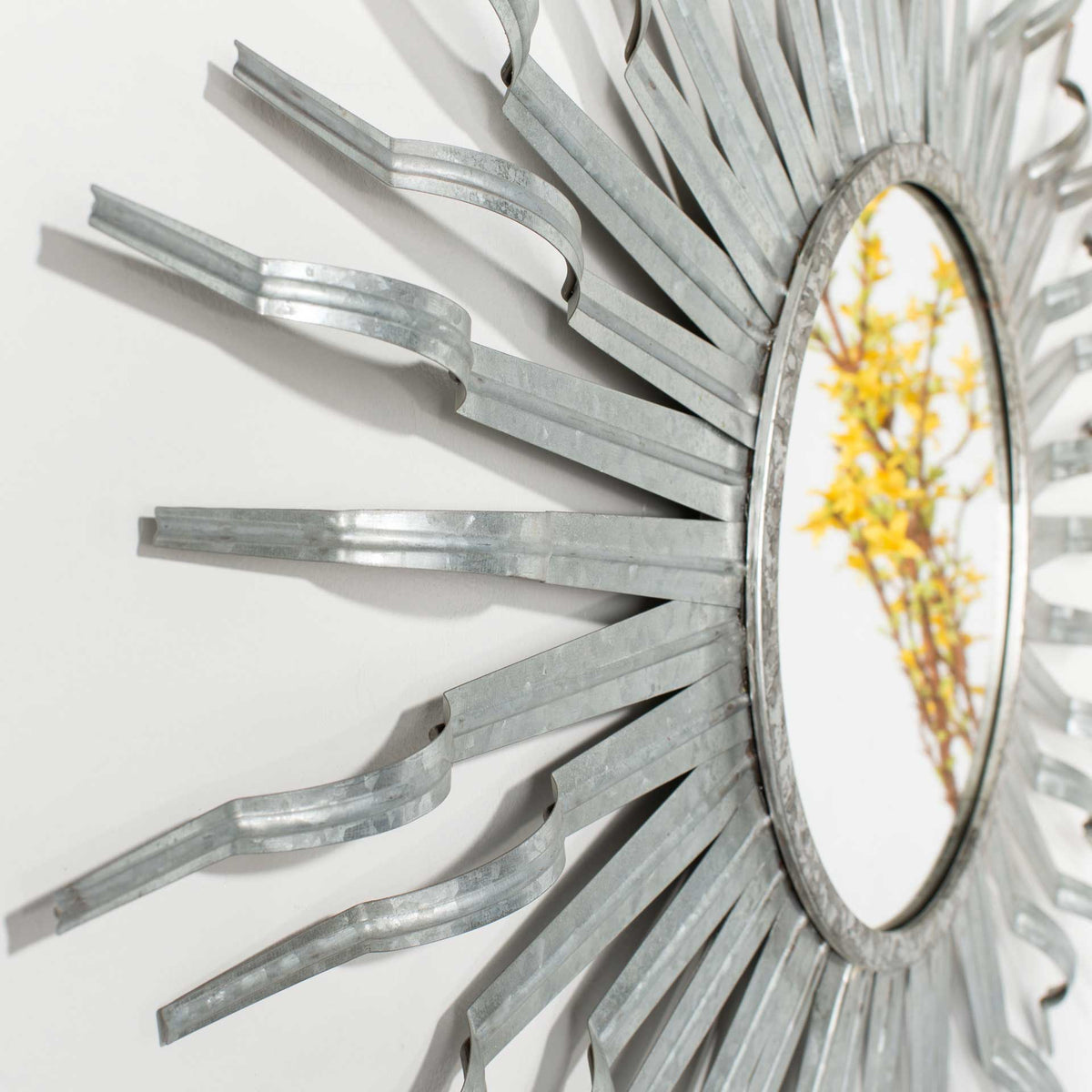 Softly textured silver rays bend outward from the circular mirror for dimensional appeal