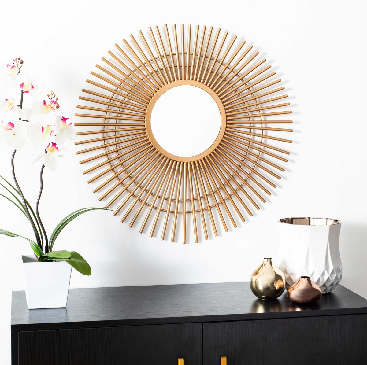 Gold sunburst mirror with slender radiating spokes adds warmth and shine above a console