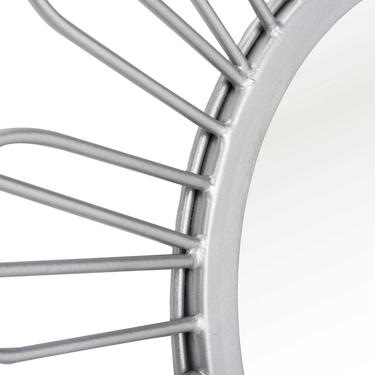 Slender silver wire loops meet a smooth, circular mirror rim