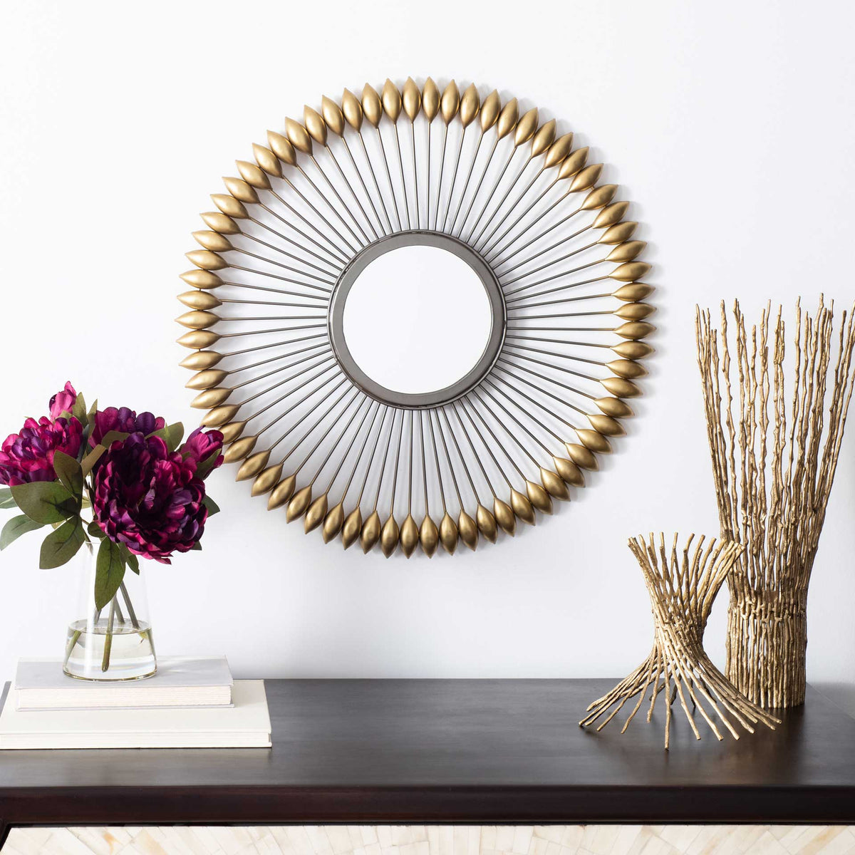 Gold-tipped sunburst mirror adds sculptural texture and warmth to the wall