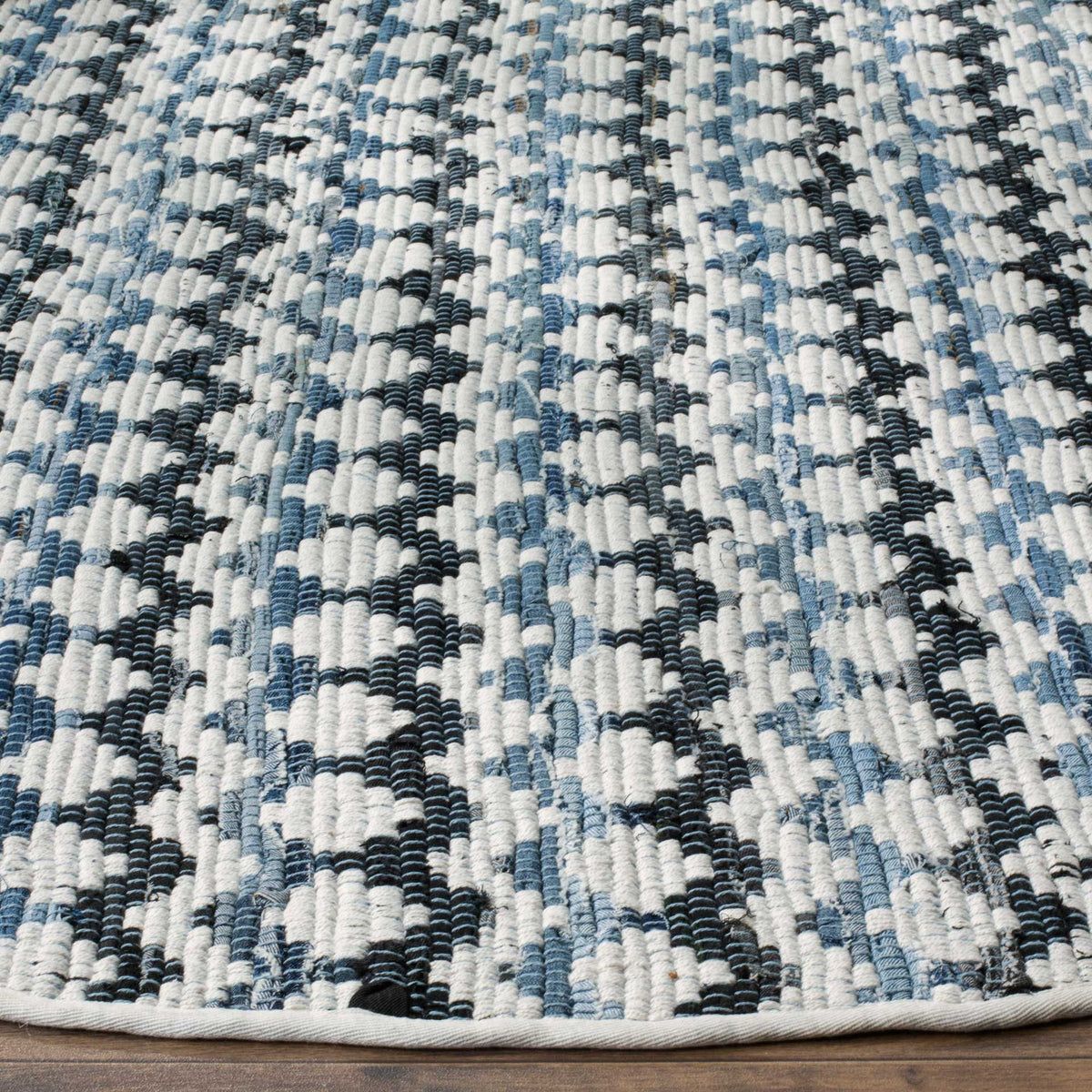 Textured ivory, blue, and black cotton weave meets a neatly bound curved edge.