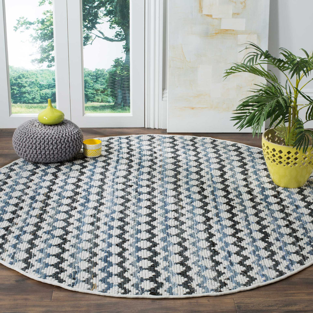 An ivory round rug with blue and black wavy lines brings graphic contrast to wood floors.